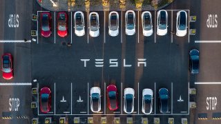 An aerial view shows cars parked at the Tesla Fremont Factory in Fremont, California on February 10, 2022.