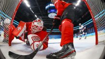 Switzerland goalkeeper Andrea Braendli, left, and Sinja Leemann slide into the goal as they defend against a charge by the United States during a preliminary round women's hockey game at the 2022 Winter Olympics, Feb. 6, 2022, in Beijing.