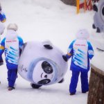 Volunteers carry an inflatable of Bing Dwen Dwen, the mascot of the 2022 Winter Olympics, at the sliding center, Feb. 13, 2022, in the Yanqing district of Beijing, China.