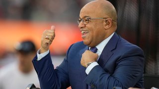 NBC broadcaster Mike Tirico motions to fans before the NFL Super Bowl 56 football game between the Los Angeles Rams and the Cincinnati Bengals, Sunday, Feb. 13, 2022, in Inglewood, Calif.