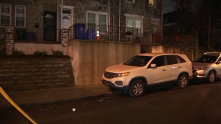 an SUV parked next to a sidewalk in front of a row home