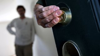 FILE - An eviction team changes the lock on the front door of a foreclosed home, Sept. 21, 2011.
