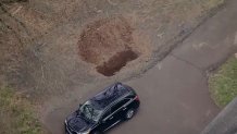 A large hole dug out next to the driveway of a home in Hilltown, where officials found the body of a Bucks County pizza shop owner.