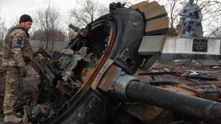 A Ukrainian service member inspects remains of a destroyed Russian T-72 tank, as Russia’s attack on Ukraine continues, in the recently liberated village of Lukianivka, in Kyiv region, Ukraine March 27, 2022.  REUTERS/Serhii Nuzhnenko