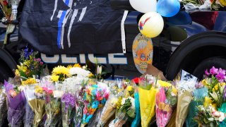 A police cruiser is covered in flowers and other items in tribute to Boulder, Colo., police officer Eric Talley, who was one of 10 victims in Monday's mass shooting at a King Soopers grocery store, Wednesday, March 24, 2021, in Boulder, Colo.