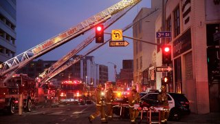 FILE - Los Angeles Fire Department firefighters work the scene of a structure fire that injured multiple firefighters, May 16, 2020.