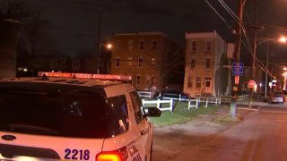 Police SUV shining headlights onto Philadelphia street.