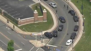 Police vehicles surround a gate at Widener University.