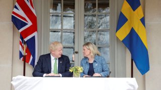 British Prime Minister Boris Johnson and Sweden’s Prime Minister Magdalena Andersson sign documents as they meet at the Swedish Prime Minister’s summer residence in Harpsund, Sweden May 11, 2022. 