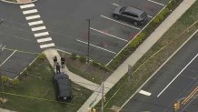 Police officers and evidence markers seen from above at a Dollar General Parking lot in Absecon, New Jersey