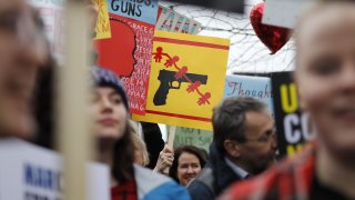 protestors carry placards and shout slogans during a demonstration calling for greater gun control