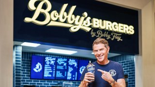 Bobby Flay in front of Bobby's Burgers restaurant