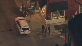 Chopper photo of a cop car and officers standing on the corner of a Center City shooting scene