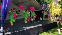 Women dance with bright-colored fans