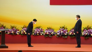 Xi Jinping, China’s president, right, swears-in John Lee, Hong Kong’s chief executive, at a ceremony in Hong Kong, China, on Friday, July 1, 2022. Hong Kong’s new security-minded leader was sworn in by President Xi Jinping as the city marks 25 years of Chinese rule, after declaring the Asian financial hub had been reborn after a crackdown on the pro-democracy opposition.