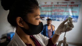 FILE- A nurse prepares to administer vaccine for COVID-19