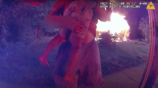 In this image taken from police bodycam video on July 11, 2022 and provided by the Lafayette, Ind., Police Department, Nick Bostic, 25, of Lafayette rescues a 6-year-old girl from a house fire in Lafayette, Ind.