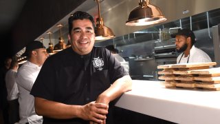 Chef Jose Garces leans on the edge of a kitchen