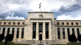 Exterior shot of the Federal Reserve building with dramatic clouds in sky.