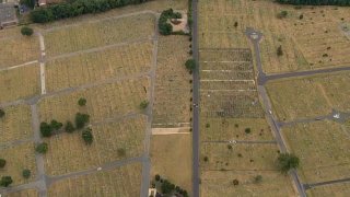 An overhead shot shows fields and a cemetery