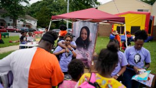 Family members of Nikiesha Thomas, from left, Sheron Mundle, aunt, Janee Fountain, cousin, and Julene Sappleton, aunt, work together to hand out donated school supplies during a Back To School Block Party in the Robinwood Community of Annapolis, Md., Sunday, Aug. 21, 2022.