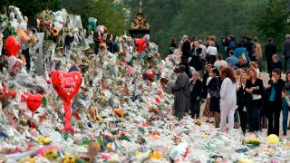 Mourners file past the tributes left in memory of Diana Princess of Wales at Kensington Palace