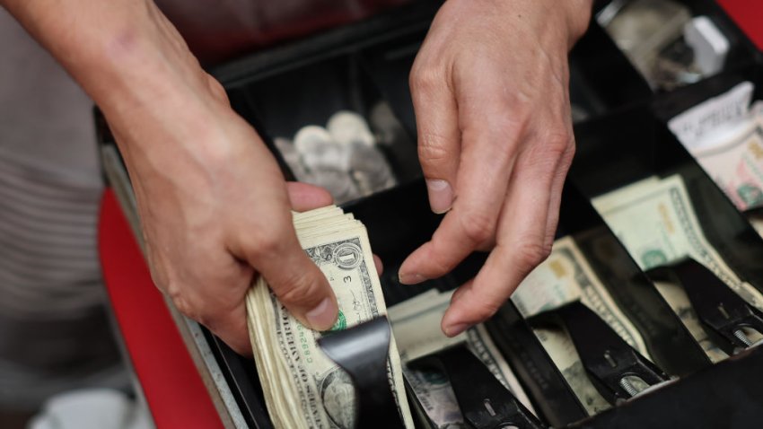 Edwin Lopez sorts the money in the cash register at Frankie’s Pizza on January 12, 2022 in Miami, Florida. The eatery’s co-owner, Renee Pasquarella, said the cost for everything needed to run the business — from cardboard boxes to pizza ingredients including cheese, tomatoes, meat —  has gone up. She said that in the 67 years the pizza place has been serving customers this has been one of the toughest times to keep it open. The Labor Department released a report indicating that the consumer price index rose 7 percent in December, compared to a year ago, the fastest increase since June 1982. (Photo by Joe Raedle/Getty Images)