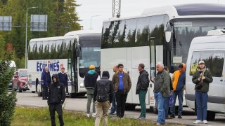 People stand near buses at the border crossing point between Finland and Russia, in Vaalimaa, Finland September 23, 2022.