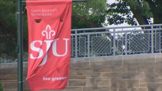 Saint Joe's flag blowing on a pole at the college campus