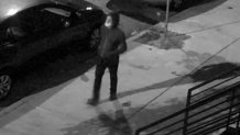 Man in hoodie and mask in black and white surveillance video
