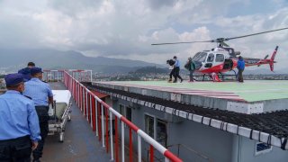 Two Nepali sherpa guides, second right and fourth right, who survived an avalanche at a lower elevation on the world’s eighth-highest mountain Mount Manaslu are taken for treatment after being flown to a hospital in Kathmandu, Nepal, Tuesday, Sept. 27, 2022.