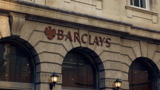 A sign hangs above an entrance to a branch of Barclays Plc bank in the City of London, U.K.