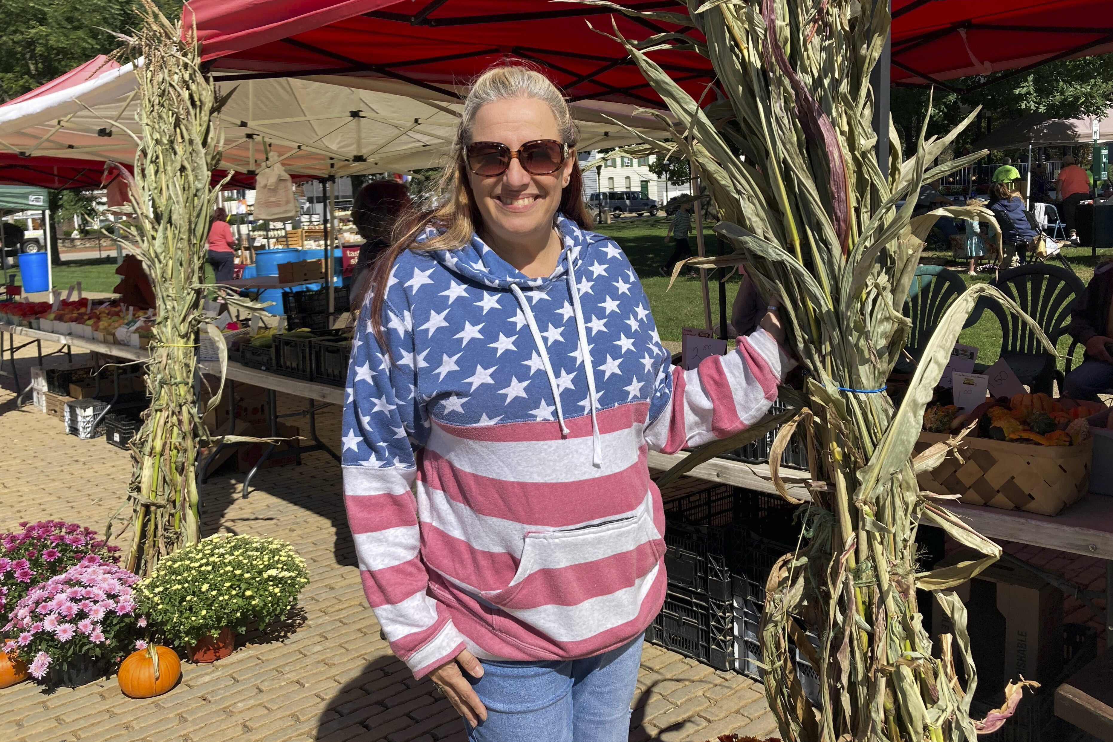 Michelle DeHosse poses for a photo at the farmer's market in downtown Monongahela, Pa., Sept. 23, 2022. DeHosse runs a custom screen-print and embroidery shop on Main Street but said she has had trouble hiring employees since the COVID-19 crisis. While she said just can’t afford the $20 an hour and health care benefits many applicants demand, she understands that many workers need both. “It’s the economy that’s the biggest concern,” she said.