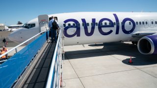 A boarding ramp leading to an Avelo Airlines plane