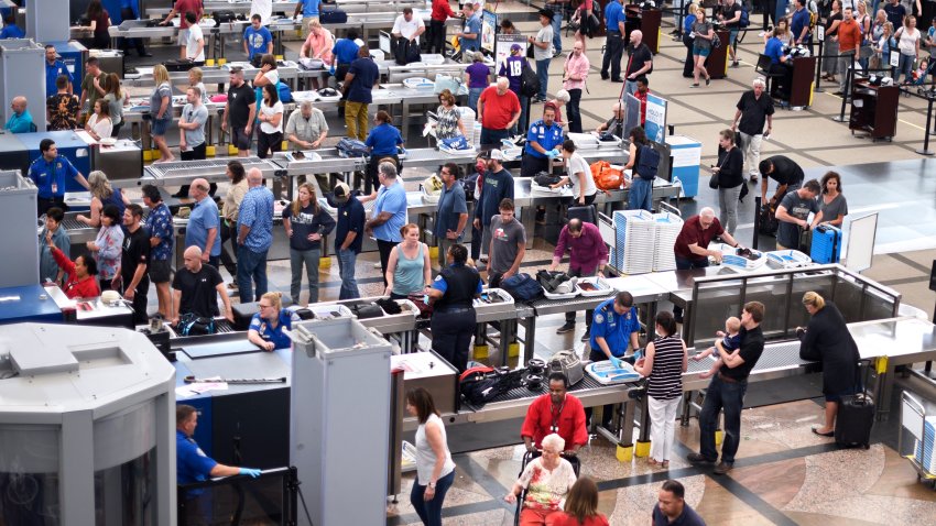 Lines of people wait to get through TSA airport screening.