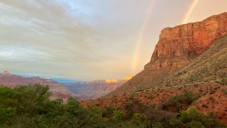 This August 2022 photo provided by the National Park Service shows a double rainbow from the ranger station porch at Indian Garden, which is now called Havasupai Gardens, in Grand Canyon National Park.