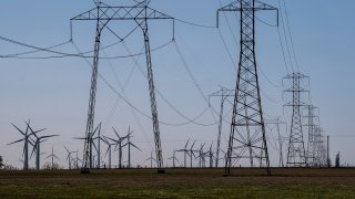 Wind turbines and power transmission lines at a wind farm near Highway 12 in Rio Vista, California, on Tuesday, March 30, 2021.