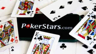 PokerStars website address surrounded by playing cards.