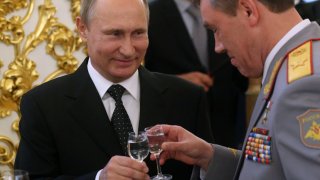 Russian President Vladimir Putin (C) toasts holding a glass of vodka with Gen. Valery Gerasimov, who is now in charge of the military campaign in Ukraine, back in 2016.