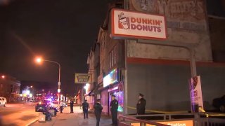 Dunkin' sign above taped off parking lot
