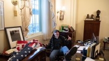 TOPSHOT - Richard Barnett, a supporter of US President Donald Trump sits inside the office of US Speaker of the House Nancy Pelosi as he protest inside the US Capitol in Washington, DC, January 6, 2021. - Demonstrators breeched security and entered the Capitol as Congress debated the a 2020 presidential election Electoral Vote Certification.