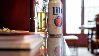 Miller Lite can next to half full glass of beer