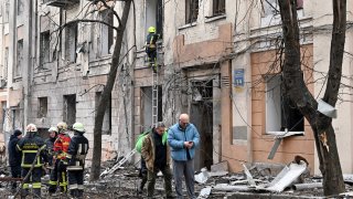 Rescuers are at work outside a partially destroyed residential building following a Russian missile strike in Kharkiv