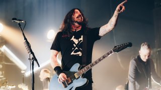 Dave Grohl points while holding a guitar