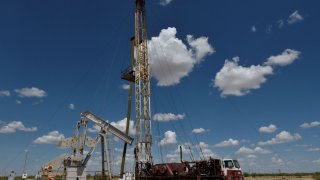 A work-over rig performs maintenance on an oil well in the Permian Basin oil production area near Wink, Texas August 22, 2018.