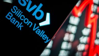 Photo illustration, the Silicon Valley Bank logo is visible on a smartphone, with the stock market index in the background on the personal computer on March 14, 2023, in Rome, Italy.