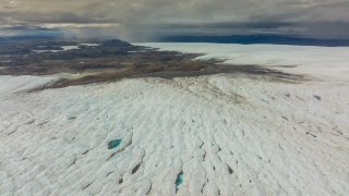 An aerial view of meltwater lakes formed at the Russell Glacier front, part of the Greenland ice sheet in Kangerlussuaq, Greenland, on August 16, 2022. Its front, a wall of ice up to 60 meters tall, advancing 25 m (82 ft) annually, is located 25 km (16 mi) east of Kangerlussuaq in the Qeqqata municipality in western Greenland and is included in the UNESCO World Heritage site of Aasivissuit – Nipisat.