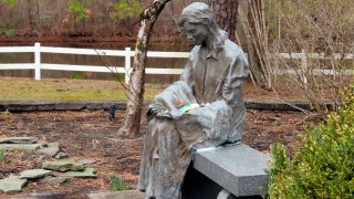 A sculpture of a grieving mother sits at a memorial garden, Feb. 21, 2023, in Toms River, N.J. for children who died from any cause.