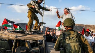 A Palestinian protester yells at an Israeli soldier as he confronts him atop an Israeli army vehicle during a protest against Israeli forces conducting an exercise in a residential area near the Palestinian village of Naqura, northwest of Nablus in the occupied West Bank, on September 4, 2019.