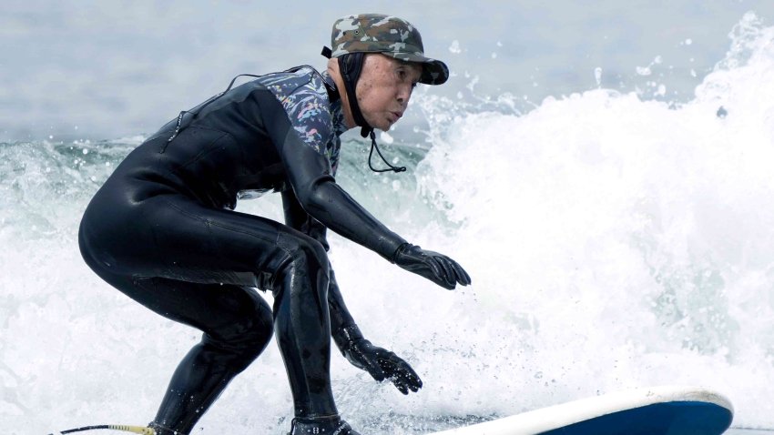 Seiichi Sano, an 89-year-old Japanese man, rides a wave at Katase Nishihama Beach, Thursday, March 30, 2023, in Fujisawa, south of Tokyo.